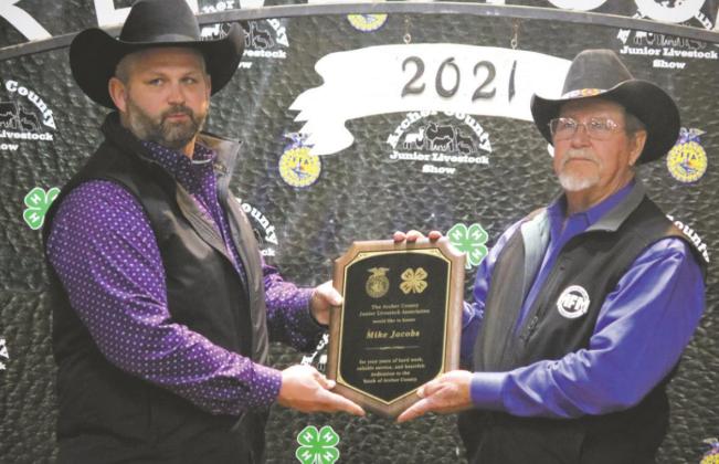 Keith McCall (left) presents a plaque to Mike Jacobs for his service to the Archer County Junior Livestock Show. Photo/Jerry Phillips