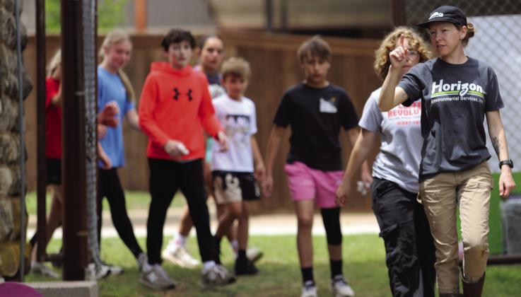 Archeologist Kailey Berube leads a group of Archer City students to an excavation site at the old county jail during the Unearthing Archer County Event organized by Horizon Environmental Services and the Archer County Museum and Arts Center. Photo/Nathan Lawson