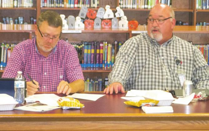 Windthorst ISD Superintendent Lonnie Hise (right) leads the Windthorst school board through some district needs as board president Chad Steinberger (left) listens on in Howard Neeb Library Monday. Photo/Nathan Lawson