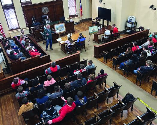 ACMAC Board Member Jerry Phillips goes over the history of the Archer County Courthouse with Hollday Middle Schoolers as part of the ACMAC field trip. Courtesy photo