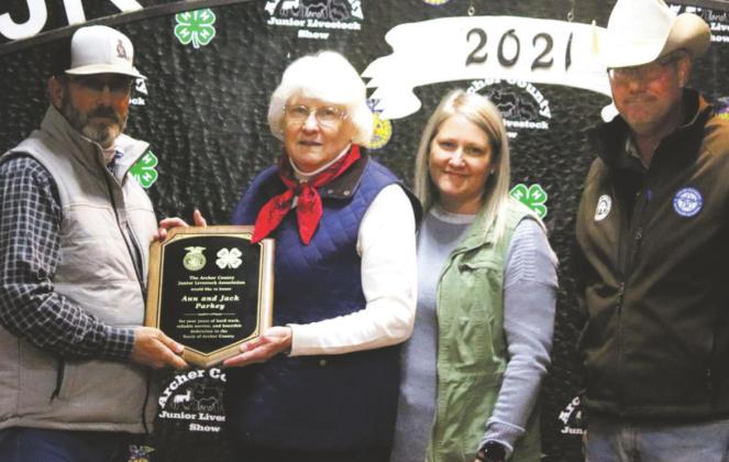 Todd Herring (left) presents a plaque to Ann Parkey and family for her and her late husband, Jack, for their service to the ACJLS. Photo/Jerry Phillips