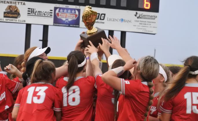 Holliday celebrates with the district championship trophy following a thrilling 7-6 win over Jacksboro in nine innings on Monday, April 26, in Henrietta.