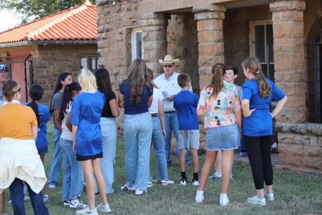 Windthorst 7th graders listen to ACMAC Volunteer Clifton Russel outside the old jail.