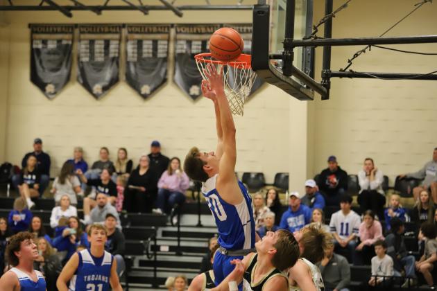 Windthorst's Kolby Teakell puts in a layup surrounded by two Archer City Wildcats