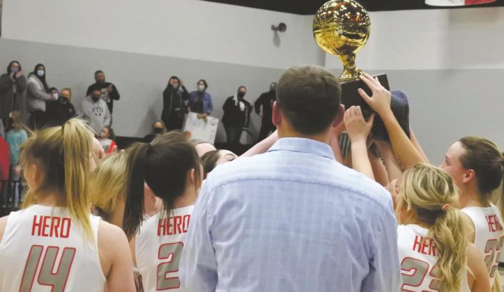 Holliday hoists the bi-district championship trophy after defeating Comanche 65-32 in Springtown. The win was the first postseason victory for the Lady Eagles since 1998. Photo/Will Edwards