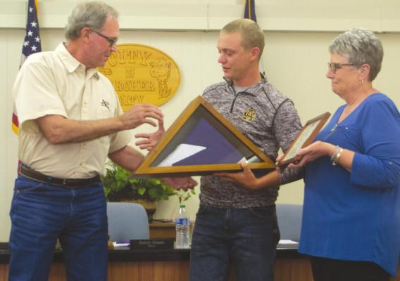 Archer City mayor Kelvin Green is presented with a flag that flew over the Texas Capitol and a plaque to honor his time as mayor during his last council meeting. Photo/Nathan Lawson