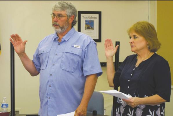 Billy Burks (left) and Leslie Hash (right) take the oath of office for the Archer City city council during its meeting Thursday, May 20. Photo/Ravyn Fager