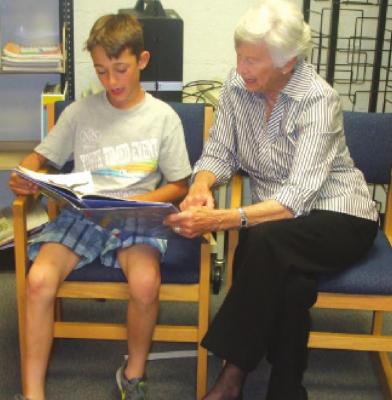Fern Starnes reads with her Book Buddy each week during school in 2018 and she will continue as a Book Buddy in 2021. File Photo