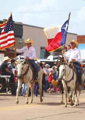 Archer County Rodeo board members Dustin Schreiber and JR Schreiber present the colors at the start of the Archer County Rodeo parade on Saturday, June 18. Photo/Nathan Lawson