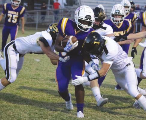 Archer City junior McKinnen Beaver wraps up for a tackle in the first quarter of the Wildcats’ 49-7 win over Munday on Thursday, Oct. 21. Photo /Jerry Phillips