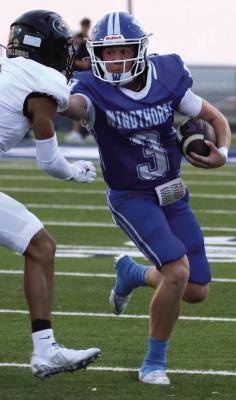 Trojan junior Brock Belcher stiff-arms an Alvord defender on his way to the sideline on Friday. Courtesy photo/Jamie Anderle