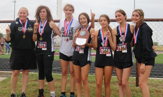 The Archer City Lady Cats’ cross country team of (L to R) Coach Mallory Mooney, Jenny Smith, Rebecca Taggart, Kassidy Marin, Landri Payne, Malia Jones and Kaydyn Ritchie won the District 9-2A championship on Wednesday, Oct. 13, in Seymour. (Photo/Jerry Phillips)