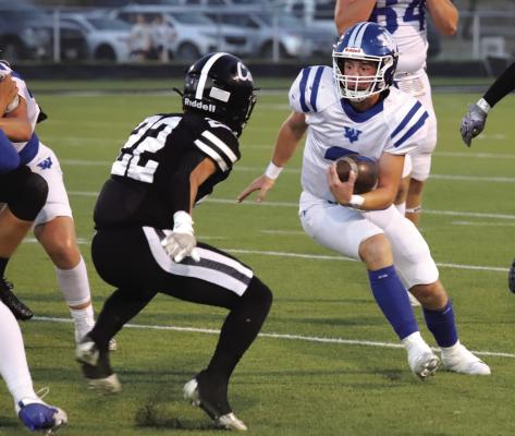 Trojan quarterback Brock Belcher looks for running room against the Archer City Wildcats on Friday, Oct. 11. Photo/Landon Davis