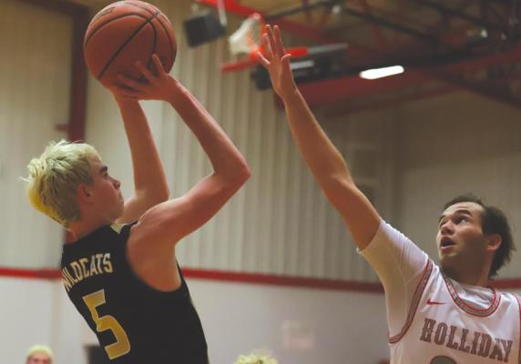Archer City’s Hayden Hilbers puts up a shot while Holliday’s Cade Borchardt goes up for a block in the Eagles’ 62-49 win over the Wildcats on Tuesday, Dec. 14. Photo/Will Edwards