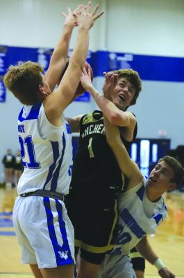 Archer City’s Joe Castles gets tangled up with Windthorst’s Jaxon Stark and Kolby Teakell in the Wildcats’ 59-52 win over Windthorst on Tues., Jan. 24. Photo/Will Edwards