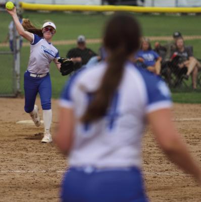 Third baseman Courtney Peterson hurls a throw to first baseman Heidi Tackett in the Trojanettes’ 9-7 win over Archer City on Monday, April 13. Photo/Landon Davis
