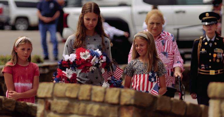 The family of fallen Marine Paul Himmels place a wreath at his memorial in the St. Mary's Catholic Church Grotto during Memorial Day services on Monday, May 26. Photo/Nathan Lawson