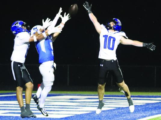 Junior Ruben Willden hauls in a touchdown catch over a pair of Mustang defenders in the fourth quarter of the Trojans 28-21 loss. Photo/Nathan Lawson