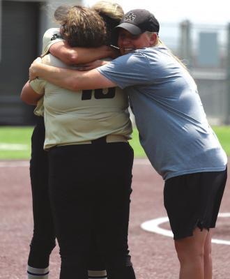 Archer City Seniors Mallory Maxwell, Maddie Lopez and Coach Mallory Mooney embrace after the game versus Crawford on Saturday, May 21. Photo/Jerry Phillips