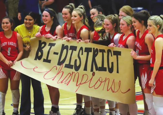 The Holliday Lady Eagles celebrate with the bi-district championship trophy following their 73-46 drubbing of Millsap on Tuesday, Feb. 15 in Graham. Photo/Will Edwards