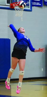 Outside hitter Charlee Wolf tosses up a serve in the Trojanettes’ volleyball game versus the Henrietta Lady Cats on Tuesday, Sept. 3. Photo/Landon Davis