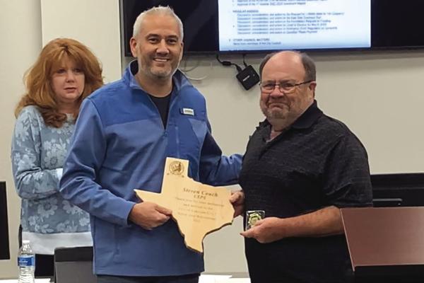 Lakeside City Mayor Cory Glassburn (left) presents a plaque and the city coin to retiring USPS worker Steven Couch for his years of service to the community during the Lakeside City council meeting on Tuesday, Jan. 17 Photo/Nathan Lawson
