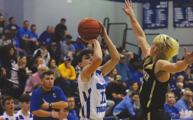 Windthorst’s Logan Cope puts up a 3-pointer as Archer City’s Kameron Moss goes up for a block in the second half of the Wildcats’ 60-53 win over the Trojans. Photo/Will Edwards