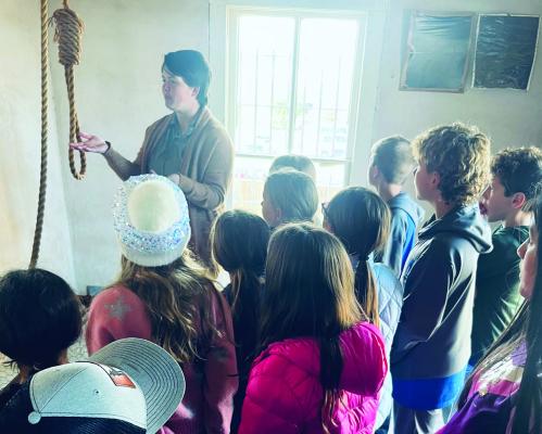 ACMAC Executive Director Callie Lawson talks about the hanging noose in the Old Archer County Jail during the ACMAC Archer County History field trip. Courtesy photos