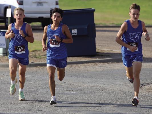L-R: Braidan Messineo, Kolton Rodger, and Jackson Zicarelli round the corner at the district cross country meet in Seymour. Photo/Landon Davis