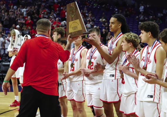 Holliday head coach Kyle Tucker awards the third place trophy to his team after the Eagles fell 6246 in the state semis to Ponder. Photo/Will Edwards