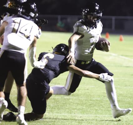 Archer City Sophomore Brayden Tedrow runs past a Dragon defender on his way to a third quarter touchdown in the Wildcats 28-7 win. Photo/Rolando Medina