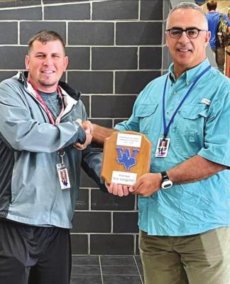 Windthorst High School teacher Tyler Owen presents Principal Roy Longcrier with the Secondary Employee of the Year award on Thursday, May 19. Courtesy photo/WISD