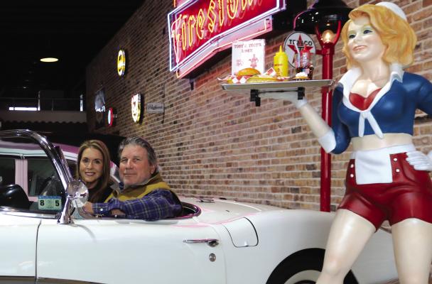 Chris and Terry Aulds sit inside one of their classic cars after moving their collection to 103 E. Main St. in Archer City. The couple opened the collection to the public on April 6. File photo