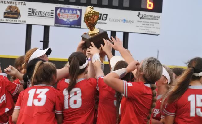 Holliday celebrates with the district championship trophy following a thrilling 7-6 win over Jacksboro in nine innings on Monday, April 26, in Henrietta.