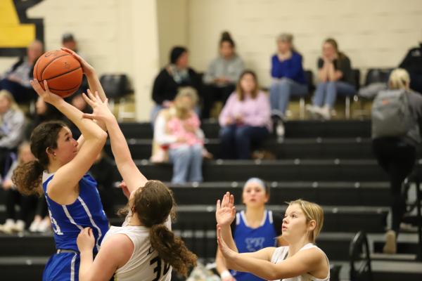 Windthorst's Abby Schroeder jump shot over two Archer City Lady Cats
