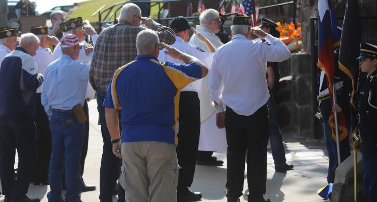 Following a blessing of the St. Mary's Grotto by Father Michael Moloney, local veterans salute for a playing of Taps to honor the 64 men who served in World War II during the 75th anniversary rededication ceremony for the St. Mary's Catholic Church Grotto on Sunday, Nov. 23. Photos/Nathan Lawson