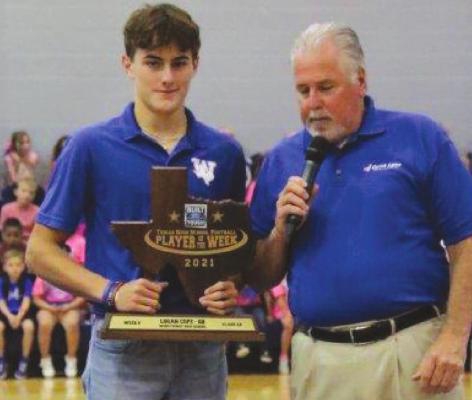 Windthorst junior quarterback Logan Cope received his Built Ford Tough Player of the Week award from Ford’s Jeff Taylor at the Trojans’ pep-rally on Thursday. Courtesy photo