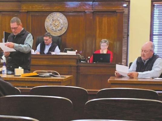 Commissioner Pat Martin III (left), County Judge Randy Jackson (2nd left), County Clerk Karren Winter and Commissioner Darren Wolf look over sealed bids on oil and fuel on Monday, March 22. Photo/Nathan Lawson