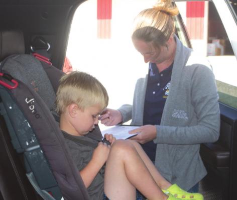 Texas A&amp;M AgriLife Extension Agent Maranda Revell checks the car seat of Case Sherril during a car safety seat check event April 13. Photo/Nathan Lawson