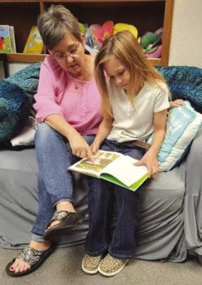 An Archer City ISD book buddy reads with an Archer City Elementary School student. The book buddy program is currently looking for volunteers. Courtesy photo