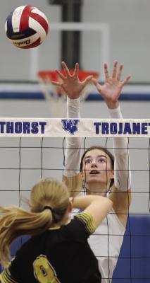 Windthorst middle Kenley Teakell leaps up for a block against Archer City’s Lyla Nichols in the first district meeting between the two on Tuesday, Sept. 30. Photo/Landon Davis