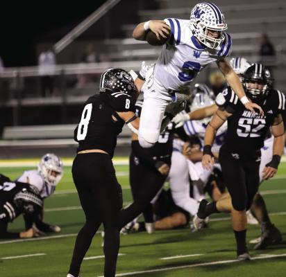 Windthorst quarterback Brock Belcher gets caught mid air by a Lindsay defender on a hurdle attempt in the Trojans' 30-27 Area round win. Photo/Nathan Lawson