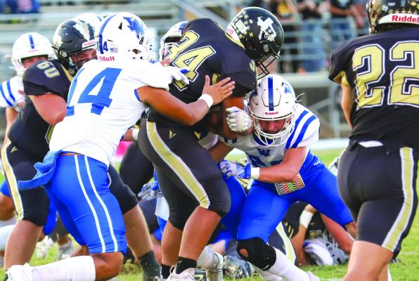 Windthorst’s Landon McLemore and Jorge Moreno bring down Haskell’s Trevor Henry in the first quarter of the Trojans’ 26-20 overtime win on Friday, Sept. 23. Photo/Will Edwards