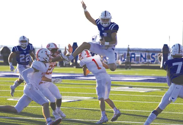 Windthorst quarterback Logan Cope goes up and over a Muenster defender in the Trojans 31-13 loss to the Hornets on Friday, Sept. 9. Cope finished with 268 of the team’s 298 yards of total offense in the setback. Photo/Nathan Lawson