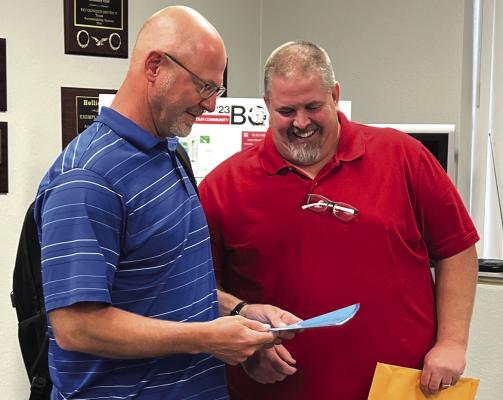Holliday school board president Blake Jurecek reviews the district’s plans to purchase a new greenhouse with fellow board member David Foster at the board meeting on Mon., April 10. Photo/Will Edwards