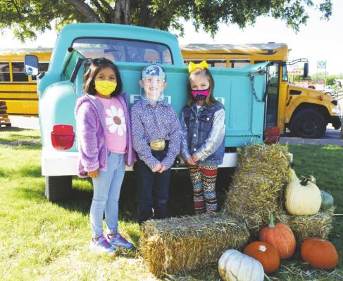 Makayla Tapia, Dempsey Hand, and Maggie Yell, kindergarteners from Ms. Berend’s class at Windthorst Elementary School, pose for a picture at their Pumpkin Patch field trip. Photo/Will Edwards