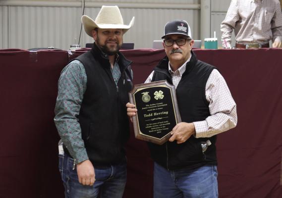 Archer County Junior Livestock Show Board President Matt Neal (left) presents Todd Herring (right) with a plaque for his 25 plus years of service on the show board. Photo/Nathan Lawson