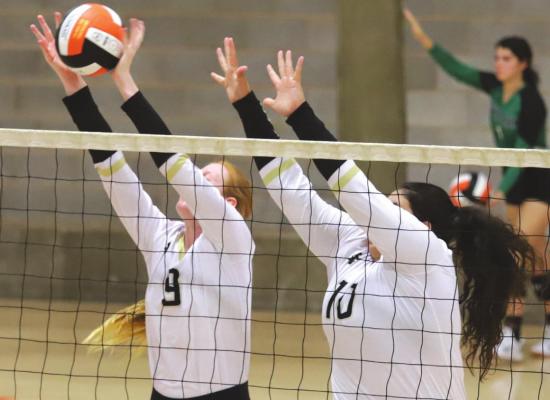 Archer City’s Olivia Vogtsberger and Bailey Grant go up for a block in the first set of the Lady Cats’ 2-1 loss to Boyd at the Cool in Boomtown Tournament on Aug. 13. Photo /Will Edwards