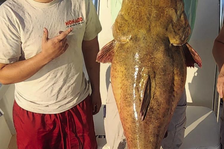 William Maxwell (left) and Brandon Brown poses with a record breaking 65.6 pound flathead catfish that Maxweel reeled in on Aug. 28. Courtesy photo