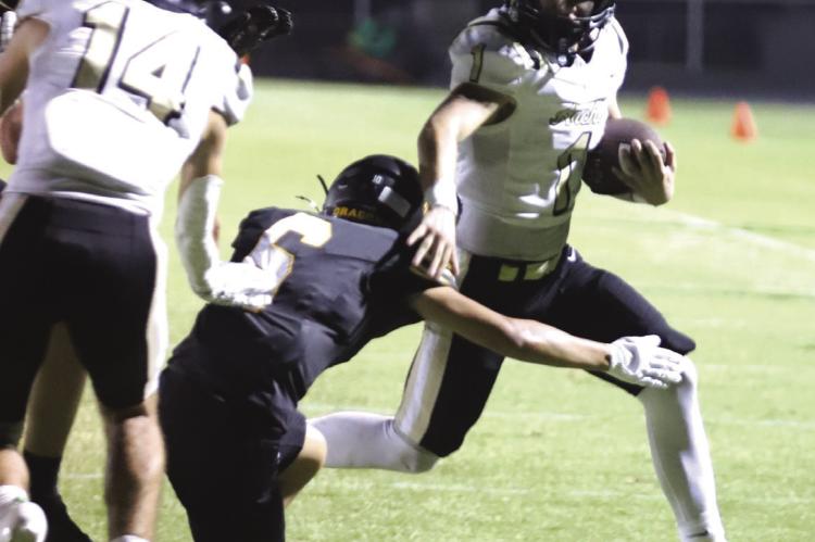 Archer City Sophomore Brayden Tedrow runs past a Dragon defender on his way to a third quarter touchdown in the Wildcats 28-7 win. Photo/Rolando Medina